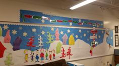 a decorated christmas bulletin board on the wall in an office space with lots of decorations