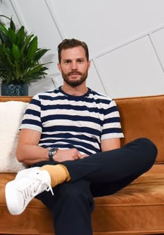 a man sitting on a couch with his legs crossed