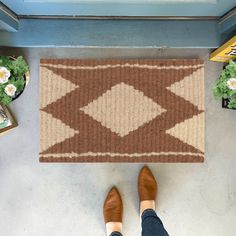 a person standing in front of a door with their feet propped up on a rug