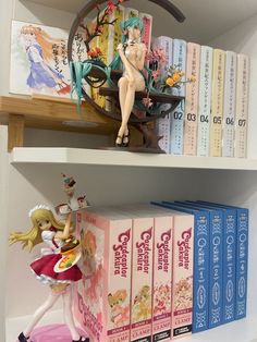 two shelves with books and figurines on top of each shelf in front of them