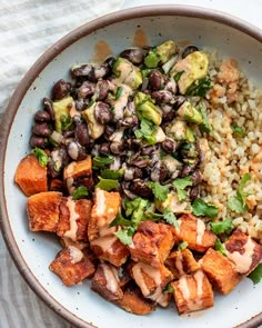 a white bowl filled with rice, beans and tofu next to broccoli