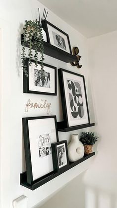 some black and white pictures are hanging on the wall next to other framed photos,