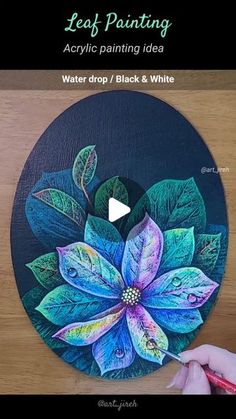 a person is painting a flower on a black and white circle with colored pencils