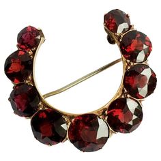 American Antique Edwardian/ post Gilded Age 14K Rosi Yellow Gold Brooch circa 1900s, nine pieces of Old European Cut Natural Pyrope Garnet 6.5 mm to 9 mm in excellent condition considering 100 Yrs of age, approximate size of 1 1/4 inch by 1 3/4 inch American Antique Edwardian 14K Rosi' Yellow Gold Natural Pyrope Garnet Brooch Measurements; 1.25 inch by 1.75 inch Stones; Pyrope Garnet, Old European Cut in excellent condition, no abrasion, damage. chips or cracks (see pictures) Hallmark; none Qual Gilded Age Jewelry, Victorian Antiques, Pyrope Garnet, Queen Anne Victorian, American Antiques, Gold Brooch, Princess Anne, Gilded Age, Gold Brooches