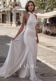 a woman in a white dress standing on the street