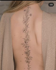 the back of a woman's neck with flowers on it