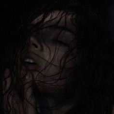 a woman with her eyes closed in the dark