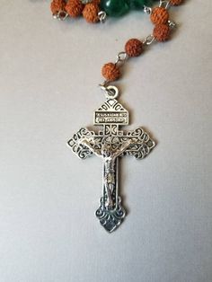 "This set of Lutheran prayer beads is wired on Stainless steel eye pins. It features Rudraksha seeds, green Malay Jade, and a detailed, well-made Pardon crucifix. This rosary is hand-wired using silver-toned stainless steel eye pins and my trusty little looper tool. The smaller beads are 6mm Rudraksha seeds. Rudraksha seeds are used for making Buddhist and Hindu malas. More info on the history of Rudraksha seeds will be added below. The larger beads are 10mm dark green Malay jade beads. Malay ja Spiritual Cross Rosary Bracelet For Gift, Gift Rosary Bracelet With 8mm Beads And Crucifix, Spiritual Rosary Bracelet With 8mm Beads And Cross, Spiritual Gift Rosary Bracelet With Cross, Spiritual Wire Wrapped Rosary As Gift, Spiritual Beaded Rosary Bracelet With Crucifix, Handmade Silver Rosary For Healing, Beaded Crucifix Rosary As Gift, Spiritual Cross Rosary Bracelet Gift