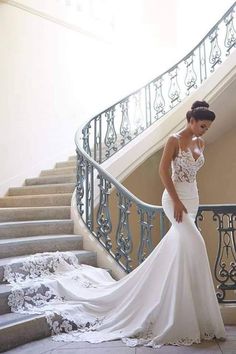 a woman in a wedding dress is standing on the stairs with her hand on her hip