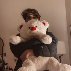 a man holding a large white teddy bear