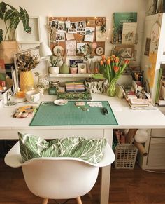 a desk with flowers and pictures on the wall