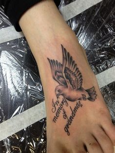 a tattoo on the foot of a person with an eagle and words written in cursive writing