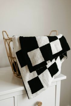 a black and white blanket sitting on top of a dresser