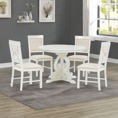 a white table and four chairs in a room