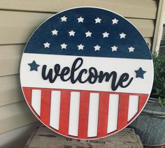 a welcome sign on the side of a house with stars and stripes painted on it