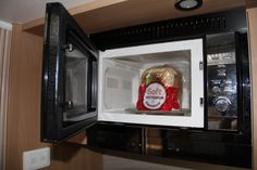 an open microwave with food in it and the door ajar to show what's inside