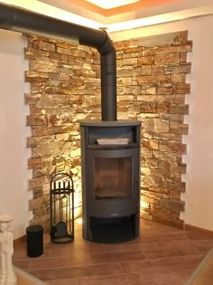 a wood burning stove sitting inside of a living room next to a wall with stone walls