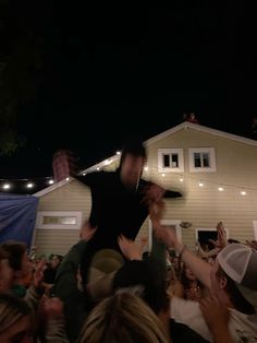 a crowd of people standing in front of a house