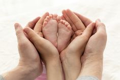 two people holding their hands together to show the baby's foot and toenails