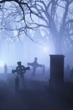 a cemetery with tombstones and crosses in the fog