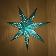 an origami star hanging from the ceiling in a room with light shining on it