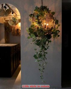 a chandelier hanging from the side of a wall with ivy growing on it