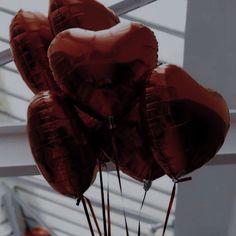 red heart shaped balloons are in a vase