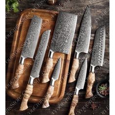 four knives on a cutting board next to some spices