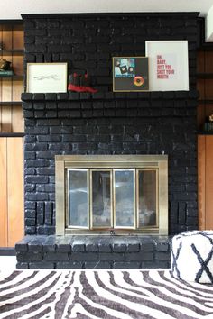 a living room with a black brick fireplace and zebra print area rug on the floor