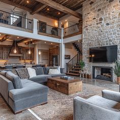 a living room filled with furniture and a fire place in front of a stone wall