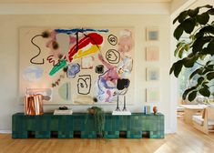 a living room filled with furniture and paintings on the wall