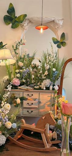 a wooden rocking chair sitting in front of a dresser with lots of flowers on it