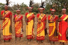 a group of people standing next to each other in front of trees and grass on a field