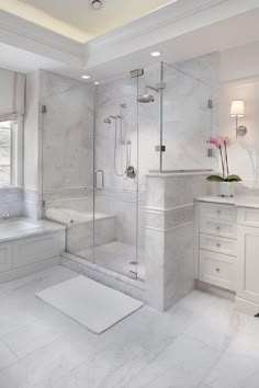 a white bathroom with a walk in shower next to a bathtub and sink area