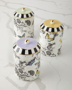 three canisters with black and white designs on them