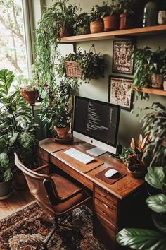 a desk with a computer and lots of plants