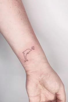 a small dolphin tattoo on the wrist