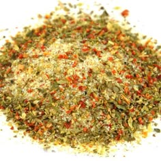 a pile of spices on top of a white surface with red, green and yellow peppers