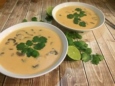 two white bowls filled with soup and garnished with cilantro