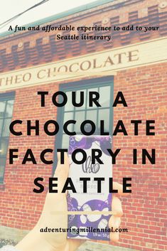 a person holding up a cell phone in front of a brick building with the words tour a chocolate factory in seattle