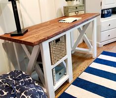 a wooden desk sitting on top of a hard wood floor next to a blue and white rug