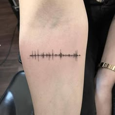 a woman's arm with a sound wave tattoo on the left side of her body