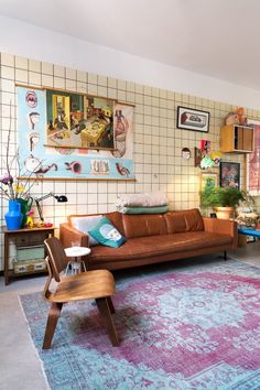 a living room filled with lots of furniture next to a wall covered in pictures and paintings