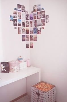 a heart shaped photo hanging on the wall above a white table with books and magazines