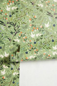 a green wallpaper with flowers and leaves on it