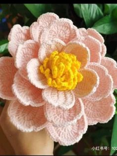 a crocheted pink flower with yellow center