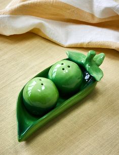 two peas in a green boat shaped like a pea pod