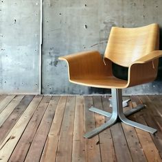 a chair sitting on top of a wooden floor next to a cement wall and wood floor