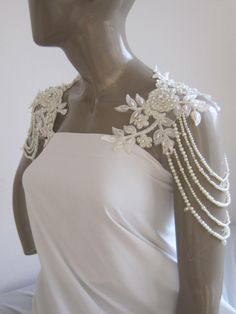 a mannequin wearing a white dress with pearls on it