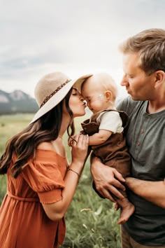 a man and woman holding a baby in their arms